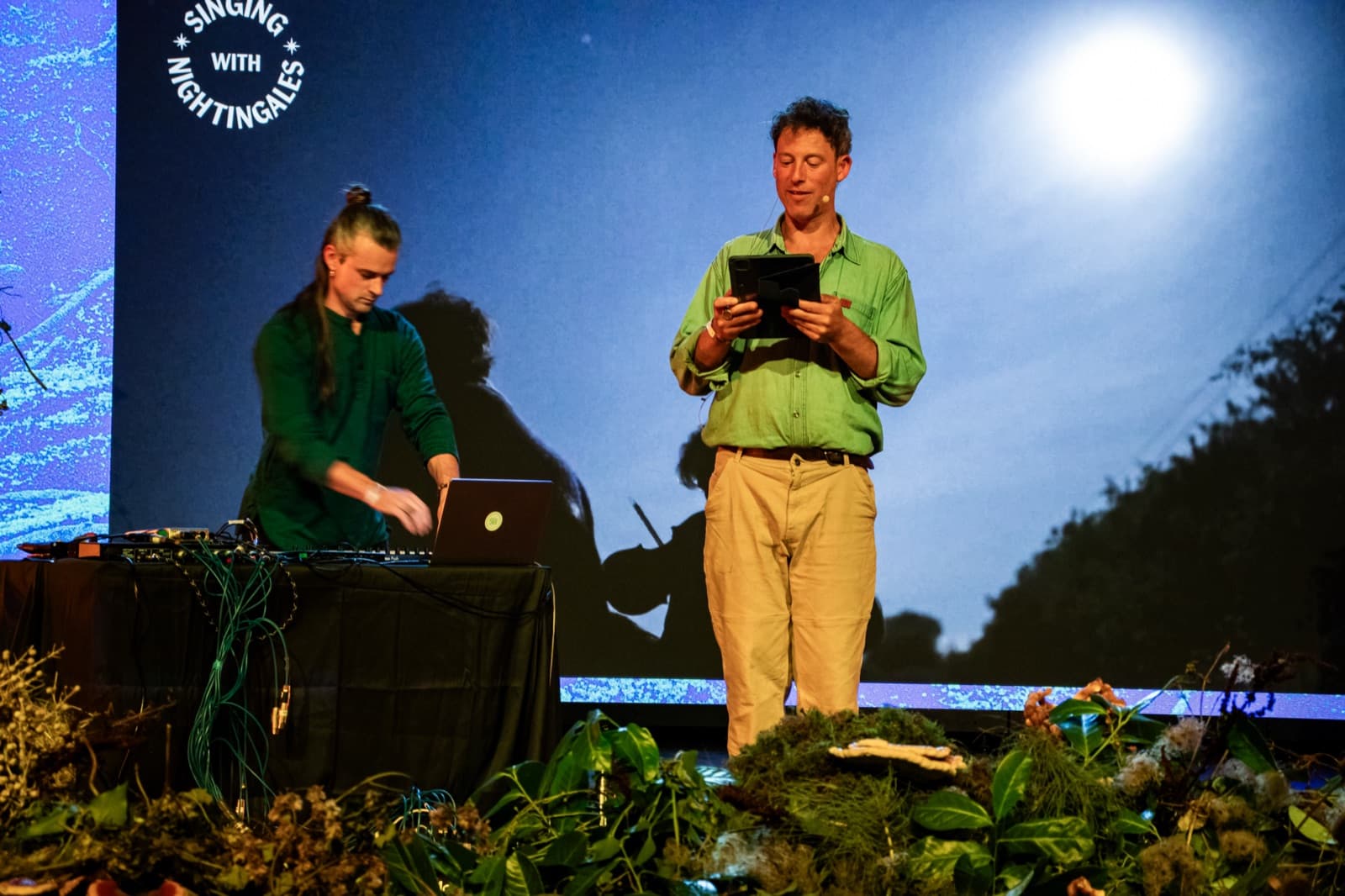 Axel Drioli at his laptop and controllers on stage with Sam Lee, Singing With Nightingales at Earthed Summit 2025